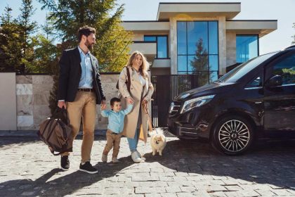 porodica pored automobila ispred kuce